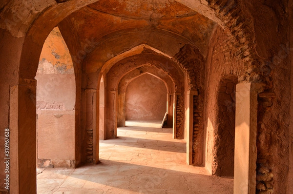 Fototapeta A mesmerizing view with sun rays create dramatic light and shadow of inside the hall of safdarjung tomb memorial from the main gate,entrance at winter morning.