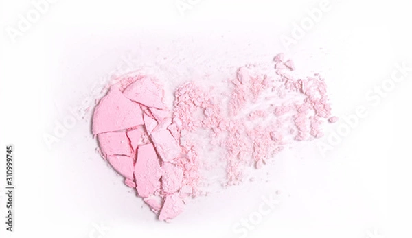 Obraz a crumb of pink highlighter powder in the shape of a broken heart on a light background, top view