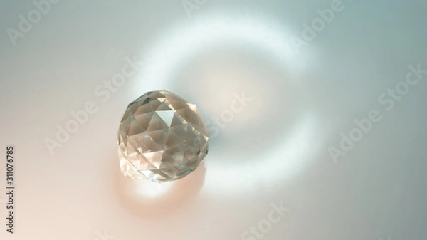 Fototapeta Large crystal on a white background with light refraction abstraction. A lot of space for an inscription or logo.