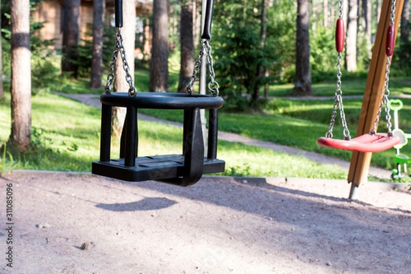 Fototapeta Two types of swings in the playground. Safe gaming equipment.