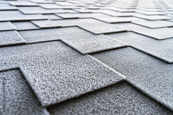 Fototapeta Close up view on asphalt roofing shingles covered with frost.