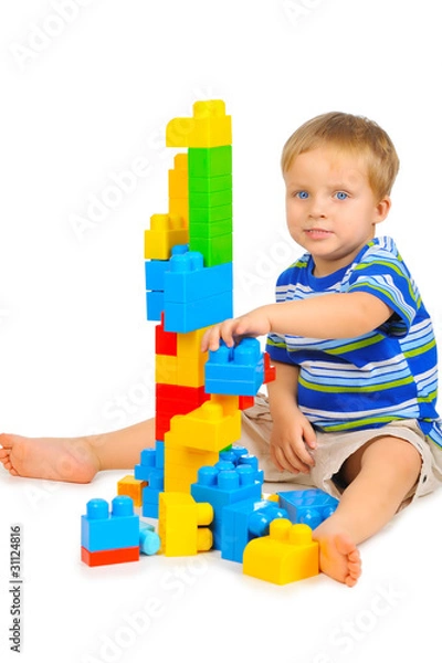 Fototapeta Cute little boy is playing with building blocks