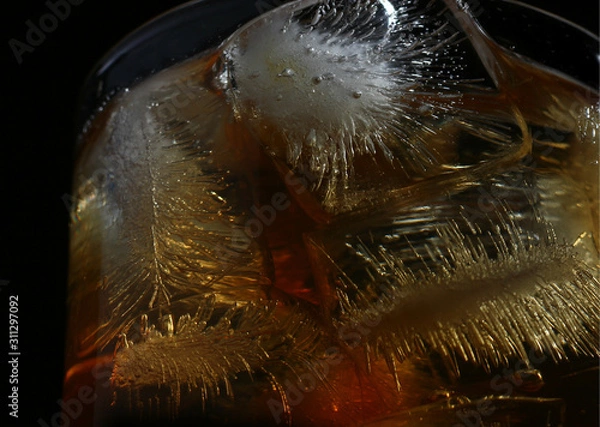 Fototapeta textured ice cubes in a glass of whisky on dark background