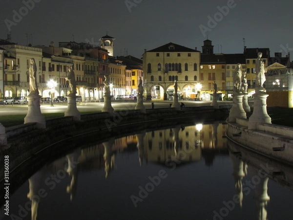 Fototapeta Padova, Italy - October 12th, 2019: Prato della Valle, in Padova, at night. The biggest square in Italy and one of the biggest in Europe, surrounded by a canal of water and by two rings of statues.