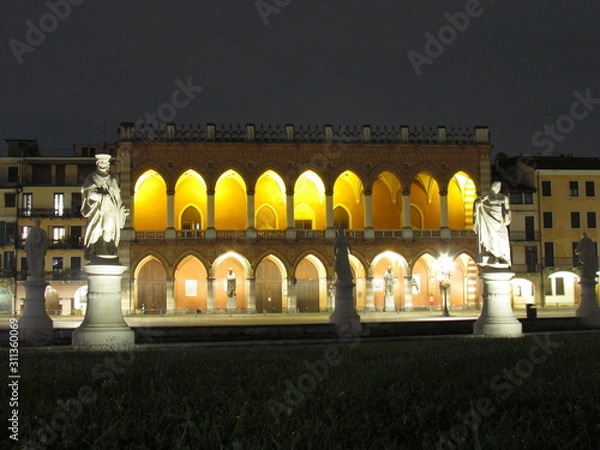 Fototapeta Padova, Italy - October 12th, 2019: Prato della Valle, in Padova, at night. The biggest square in Italy and one of the biggest in Europe, surrounded by a canal of water and by two rings of statues.