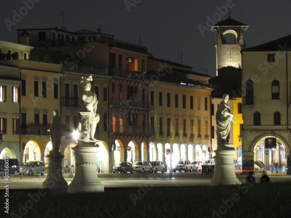 Fototapeta Padova, Italy - October 12th, 2019: Prato della Valle, in Padova, at night. The biggest square in Italy and one of the biggest in Europe, surrounded by a canal of water and by two rings of statues.
