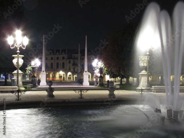 Fototapeta Padova, Italy - October 12th, 2019: Prato della Valle, in Padova, at night. The biggest square in Italy and one of the biggest in Europe, surrounded by a canal of water and by two rings of statues.