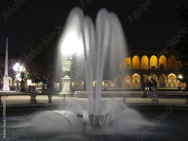 Fototapeta Padova, Italy - October 12th, 2019: Prato della Valle, in Padova, at night. The biggest square in Italy and one of the biggest in Europe, surrounded by a canal of water and by two rings of statues.