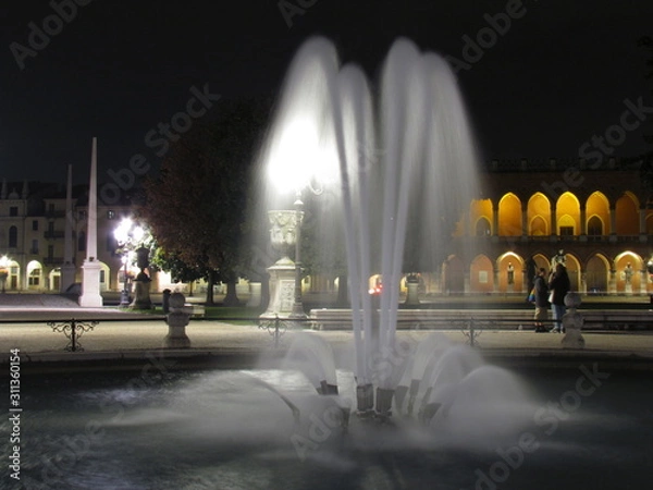 Fototapeta Padova, Italy - October 12th, 2019: Prato della Valle, in Padova, at night. The biggest square in Italy and one of the biggest in Europe, surrounded by a canal of water and by two rings of statues.