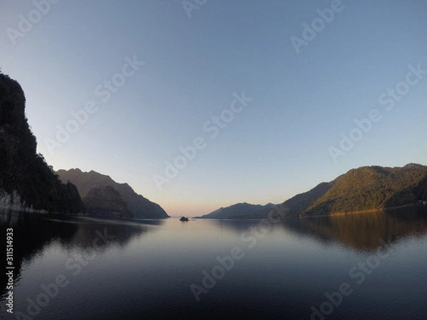 Fototapeta Natural reservoir view surrounded by mountains and surrounded forest