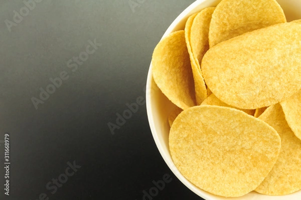 Obraz potato chips on bowl on black background.