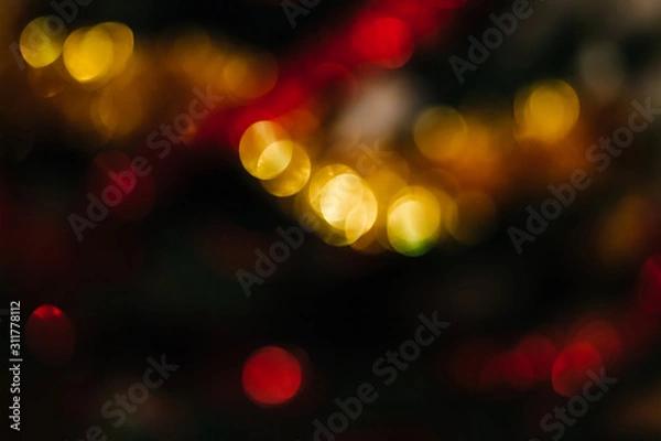 Fototapeta Bokeh of New Year and Christmas lights and decor. Colorful Christmas abstract background. Blurred and glowing lights. Bokeh lens effect from lighting spots.