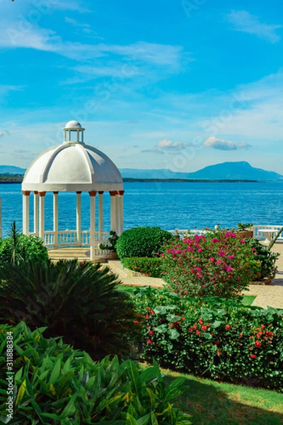 Obraz Beautiful white gazebo and tropical flower garden on Caribbean ocean background, summer mountain view , Sosua, Puerto Plata, Dominican Republic