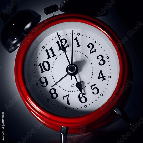 Obraz red alarm clock on dark background
