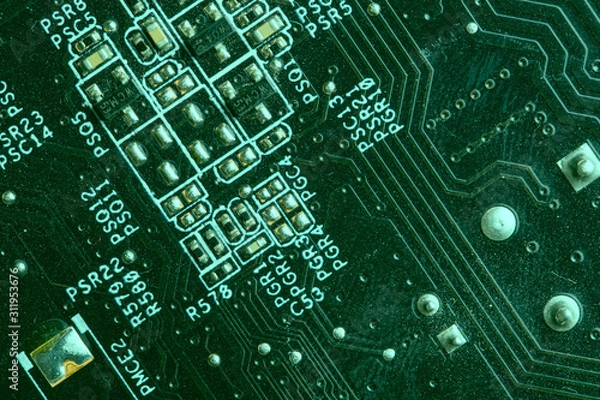 Fototapeta A close up macro photo of a generic technology motherboard circuit board (pcb) light with a green flash gel on a diagonal angle