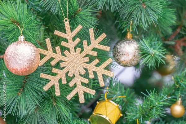 Obraz Beautiful Christmas star hanging from a decorated Christmas tree