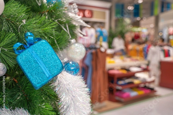 Fototapeta Beautiful Christmas gift boxes hanging from a decorated Christmas tree