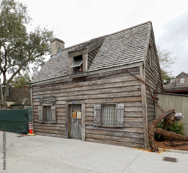 Fototapeta The oldest wooden school house in the United States, located in St. Augustine, Florida.  The house is said to be haunted as a mannequin looks out of the window, a very popular tourist destination.