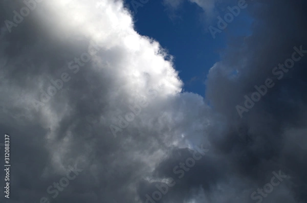 Obraz Clouds are almost black against a bright blue sky before a strong thunderstorm