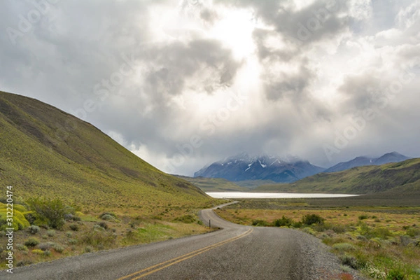 Obraz paisaje de carretera con diraccion a laguna con un fondo a las montañas del parque Torres del Paine