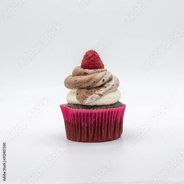 Fototapeta chocolate cupcake with frosting and raspberry garnish