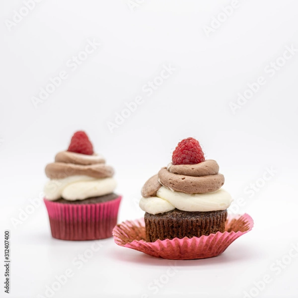 Fototapeta chocolate cupcake with frosting and raspberry garnish