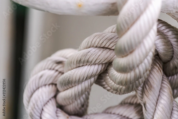 Fototapeta sailor knot made with thick white rope with white rusty background