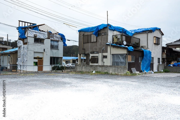 Obraz 強風被害を受けた瓦屋根の民家