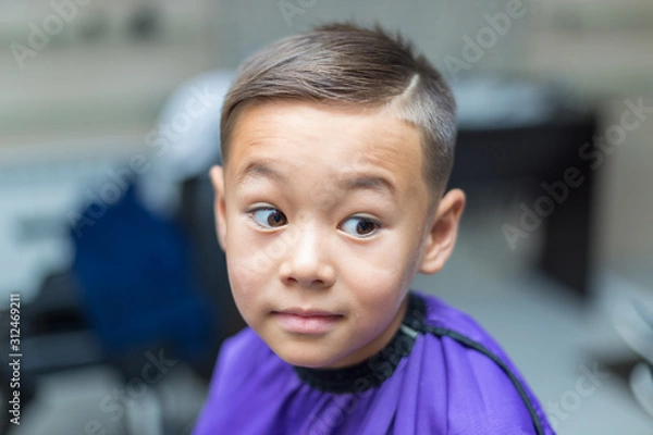 Obraz Close-up portrait of an attractive handsome smiling little boy looking at camera after haircut. Hair. Beautiful boy. Six year old boy smiling and having fun