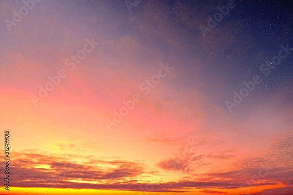 Fototapeta Orange sky at sunset and red clouds landscape against bright star on black universe background. Wide panorama view of stars in space nature at dark time. Starry night at night wallpaper