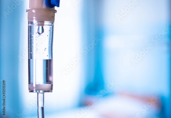 Fototapeta Dripping medical perfusion close up equipment in clinic background. Saline Solution IV Drip Fluid for Infusion in Hospital. Intravenous infusion tube equipment in hospital. Health patient concept.