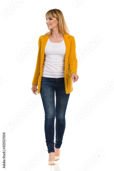 Obraz Young Woman In Yellow Unbuttoned Jacket And High Heels Is Walking Towards Camera