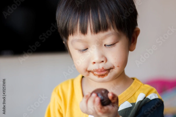 Obraz Young asian boy with face covered in chocolate