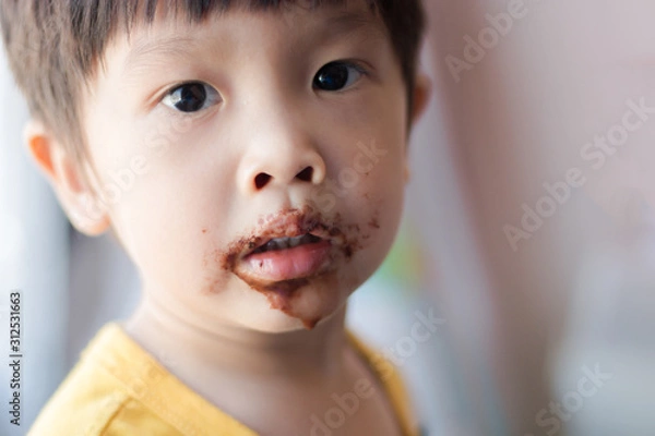 Obraz Young asian boy with face covered in chocolate
