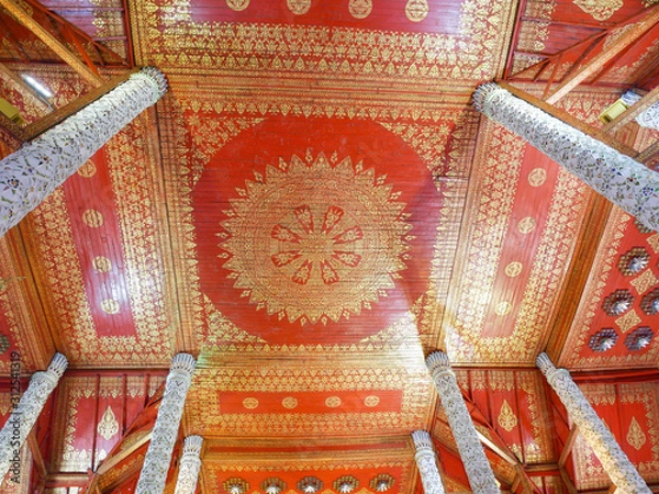 Fototapeta The ceiling of the church is red and alternating with golden Thai designs.