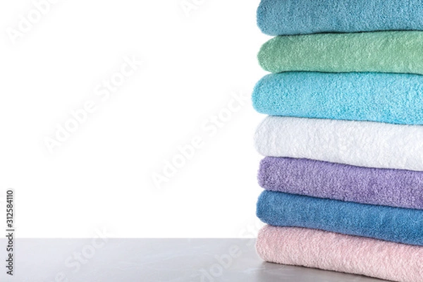 Fototapeta Fresh towels on light grey table against white background. Space for text