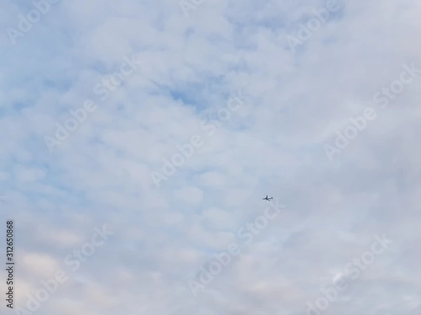 Obraz Tiny airplane on a vast cloudy sky