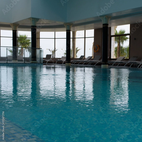 Fototapeta Empty indoors public swimming pool with clear water.