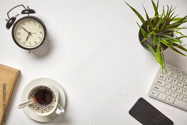 Fototapeta Flat lay on workspace with laptop computer, alarm clock and black coffee. With copy space, background, top view.