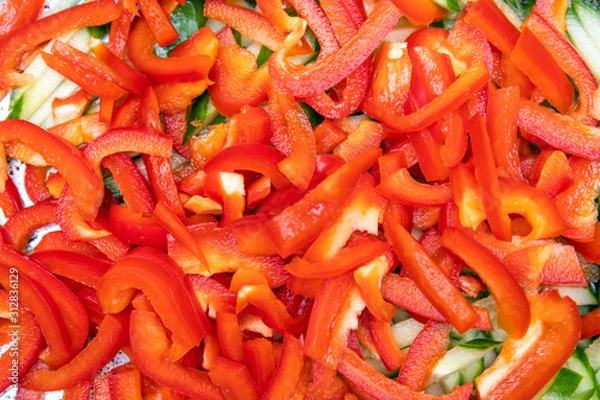 Obraz chopped red bell pepper and cucumbers, background