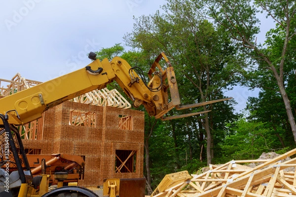 Obraz New construction home framing against a boom truck forklift