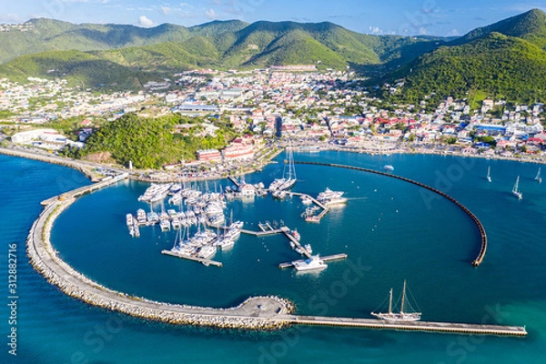 Fototapeta Arial view of Marigot, the main town and capital in the French Saint Martin, sharing the same island with dutch Sint Maarten. Fort St. Louis on a hill, yachts and a circular breakwaters of the marina