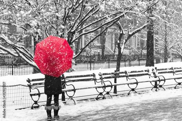 Obraz Woman with red umbrella walking through a snowy black and white winter scene in New York City