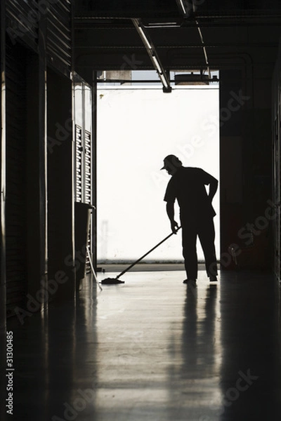 Obraz Silhouette of man moping floor