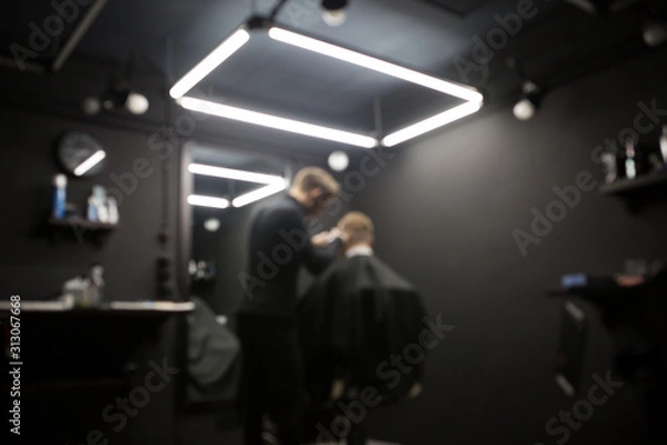 Fototapeta Blurred photo of a barber shop room in black style and lamps.