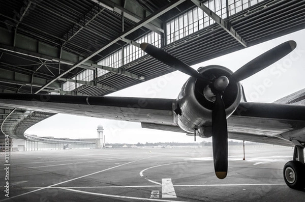 Fototapeta BERLIN, GERMANY - December 22, 2019: Building of Tempelhof in Berlin. Empty airfield. In the front a wing  and engine of a airplane