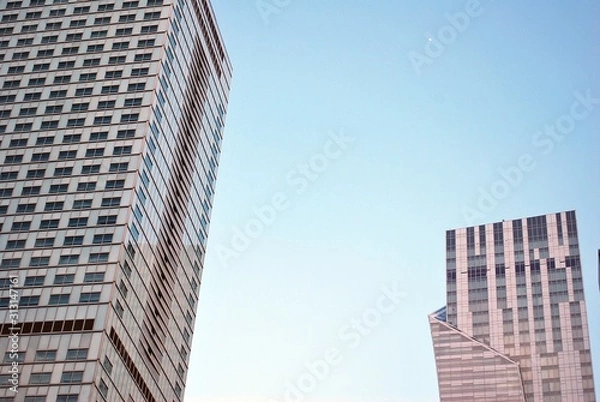 Fototapeta Abstract image of looking up at modern glass and concrete building. Architectural exterior detail of office building. 