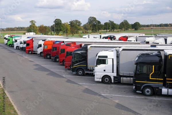 Fototapeta Different types of trucks in a crowded parking lot off the highway.