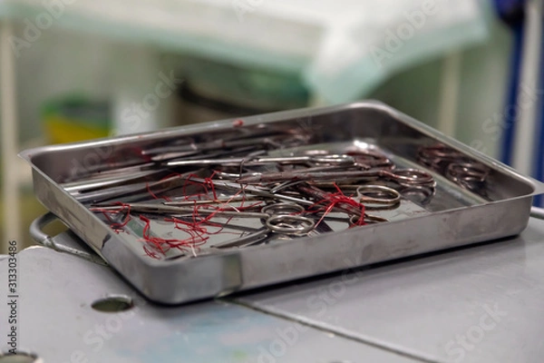 Fototapeta Surgical instruments after surgery are folded in the tray.