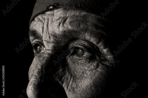 Fototapeta The sad eyes of a lonely old grandmother. Eyes on the wrinkled face of an old mother. Tearful eyes of an old grandmother close-up